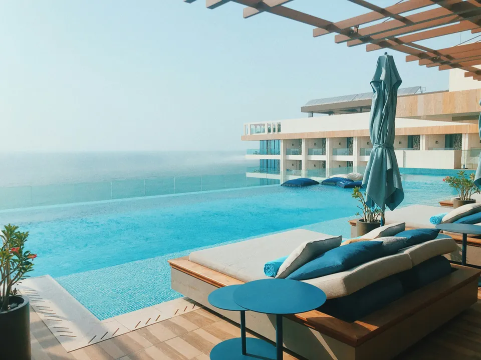 Infinity pool and daybed overlooking a calm sea