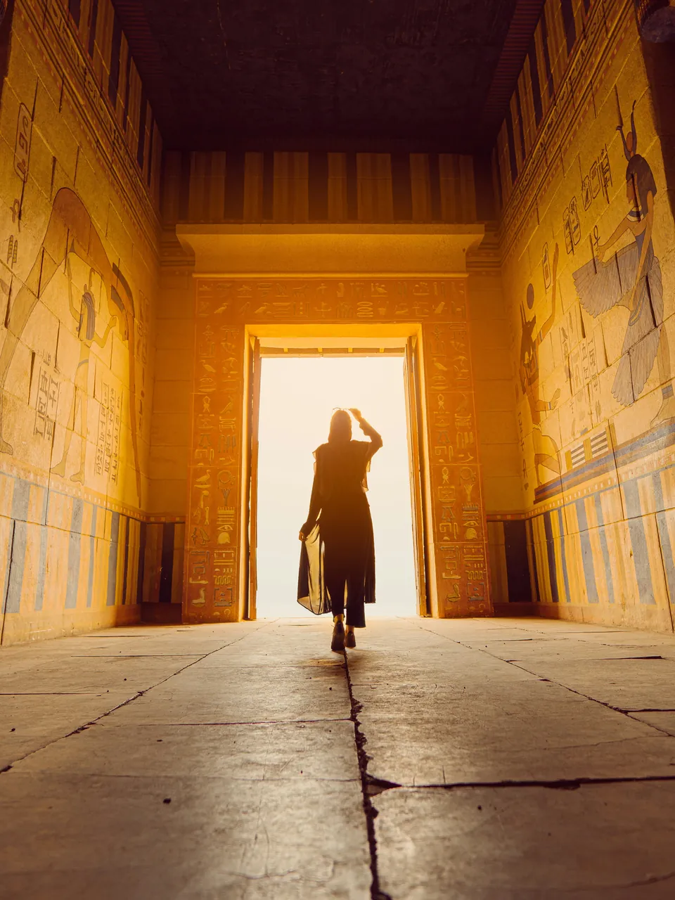 A traveller walking through a sunlit temple doorway